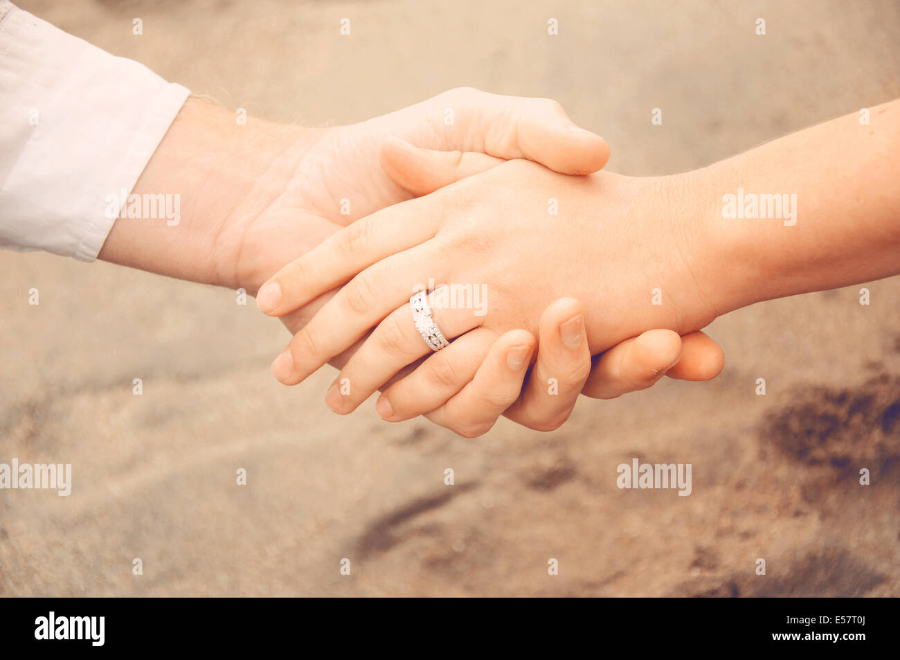 manos-en-la-playa-una-nueva-pareja-mostrando-su-anillo-de-compromiso-e57t0j.jpg